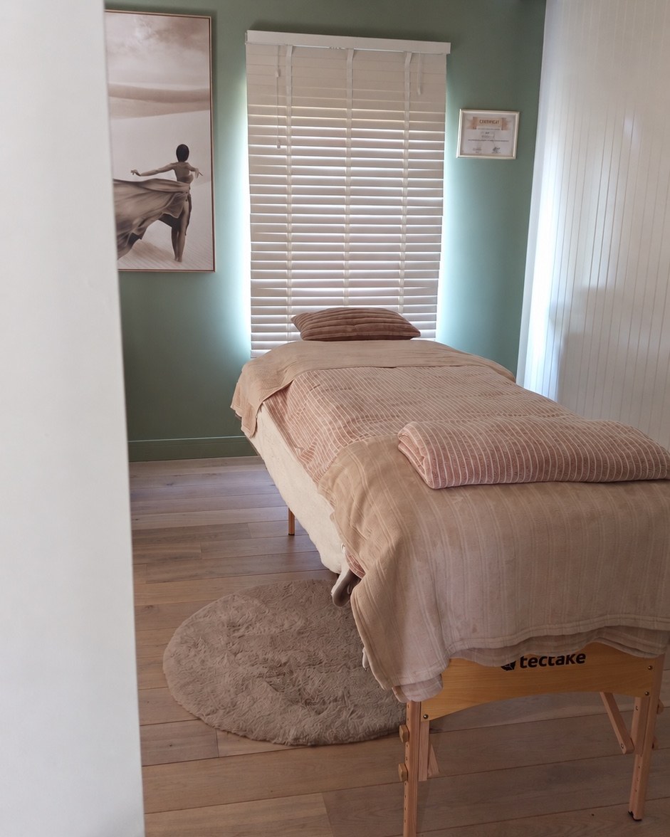 La cabine de soin : la table de massage devant la fenêtre